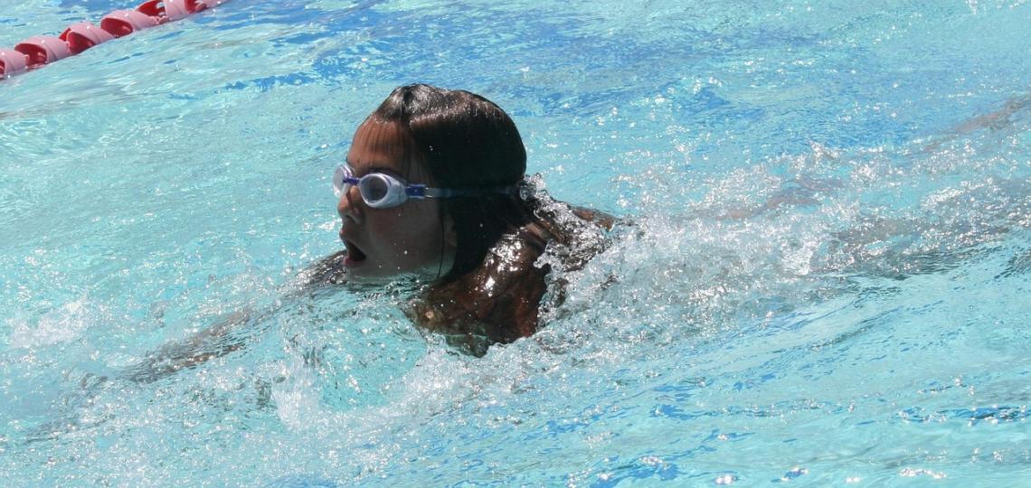 Photo of a young girl swimming wearign goggles.