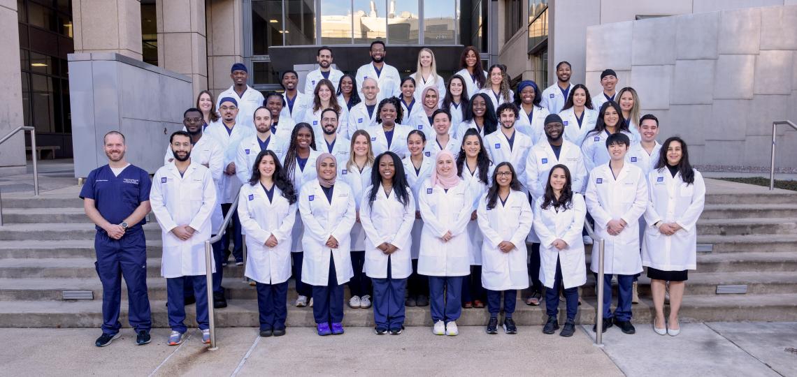large group of doctors standing on outdoor steps and smiling