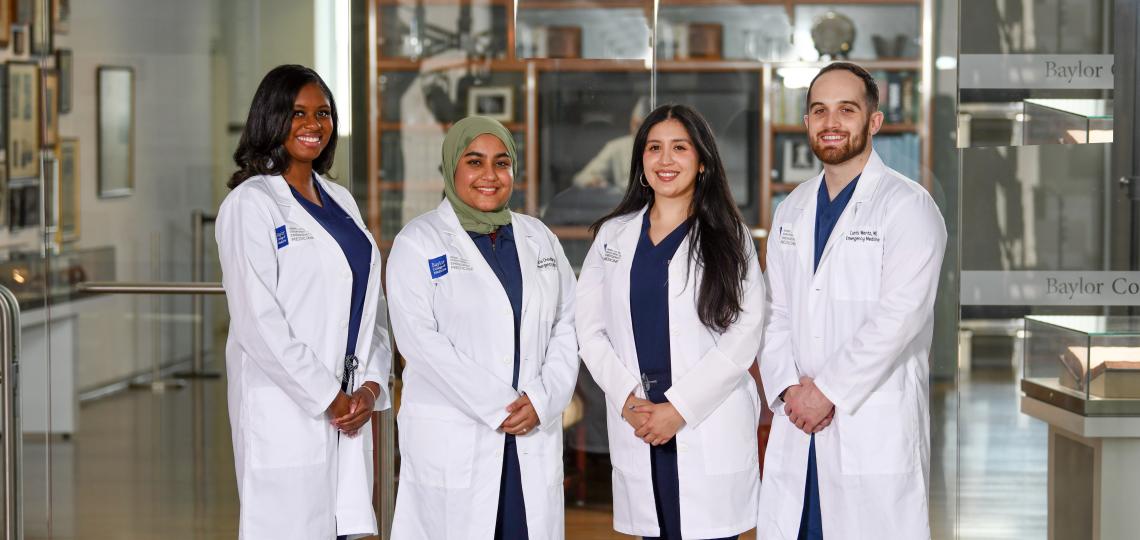 4 doctors standing together smiling
