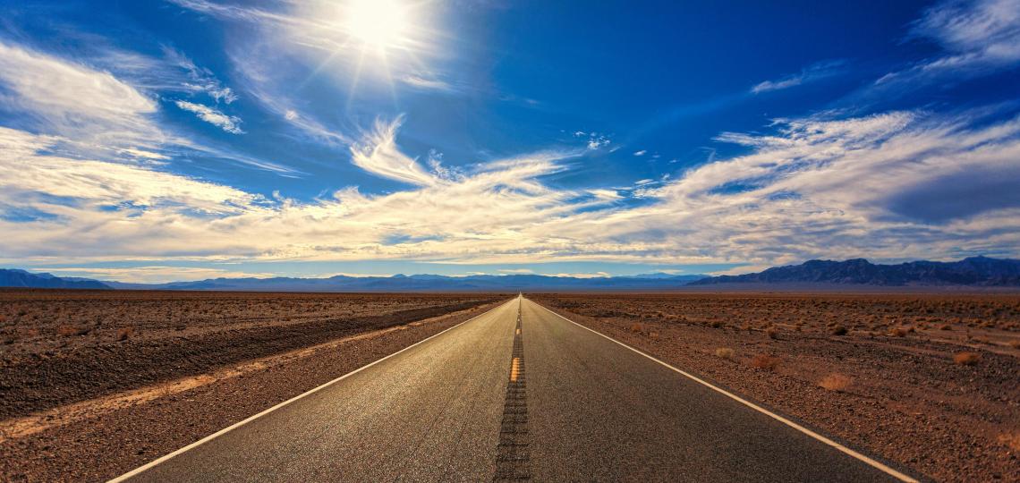 Photo of an empty road to represent a road trip and traveling