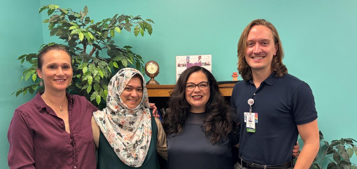 4 people standing together smiling