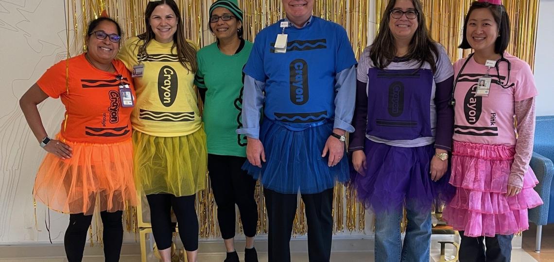 group of people in crayon costumes, smiling