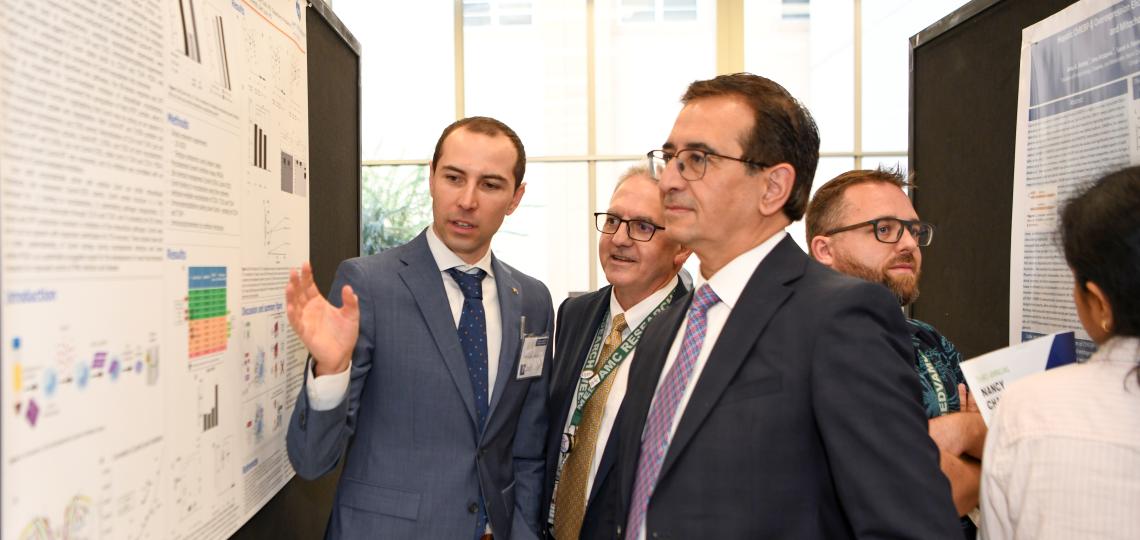 a few people in suits looking at a medical poster