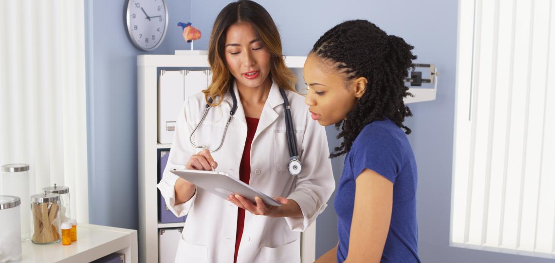 a doctor looking at paperwork with her patient
