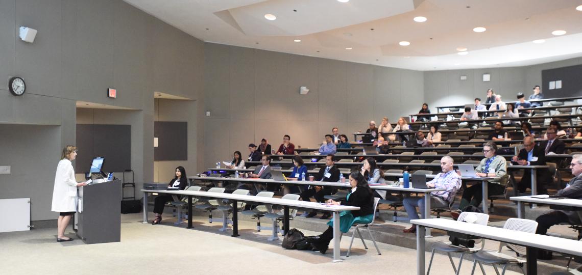 Group of people in classroom-style room, presenter at front