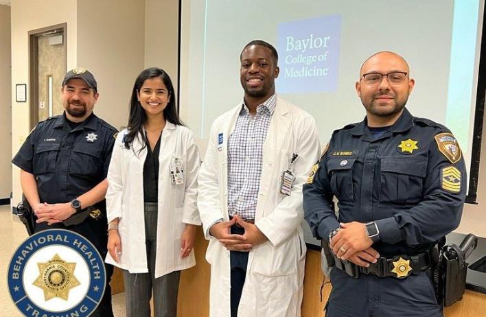 Two police officers and two doctors pose after a presentation.