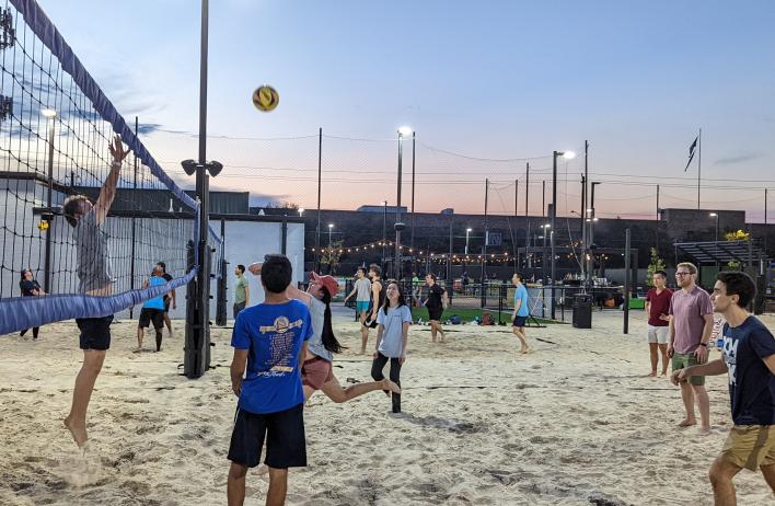 Internal Medicine residents play volleyball on a sandy pitch