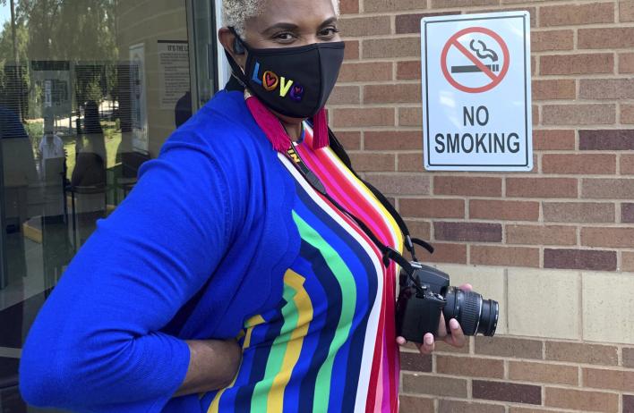 An Emergency Medicine Residency Wellness member wearing a mask and holding a camera.