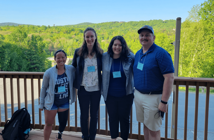 Four lab members standing outside in Dover, Vermonet during the 2023 Gordon Research Conference.
