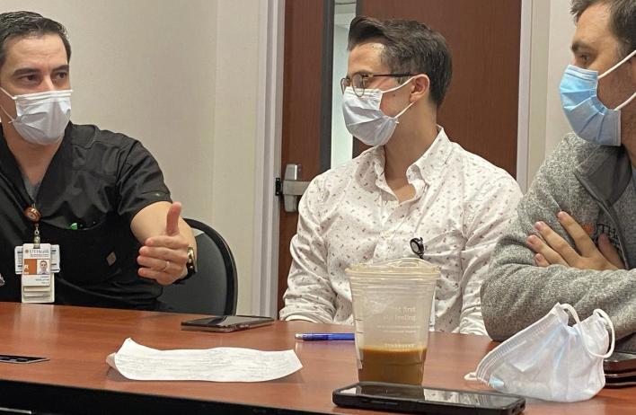 Three masked students talking together at a table