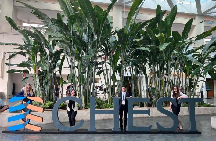 Four residents standing behind a large sign that reads CHEST
