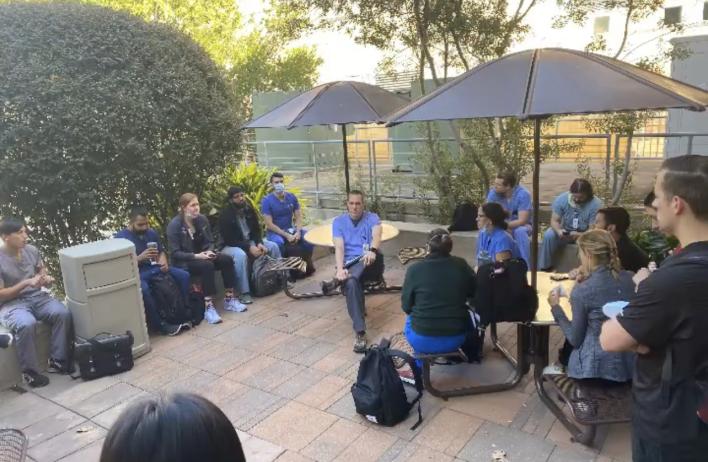 Students outside on a patio, talking with each other