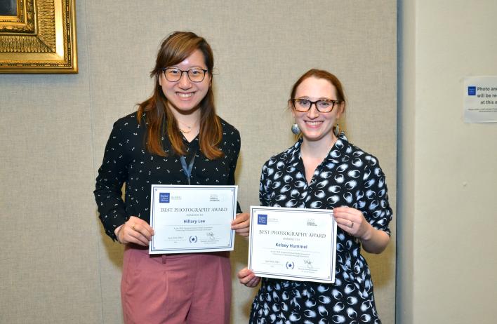 Two women holding certificate awards for best photography