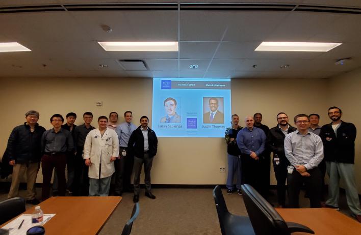 group of people smiling besides a presentation