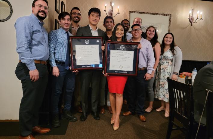 group of people holding two awards plaques