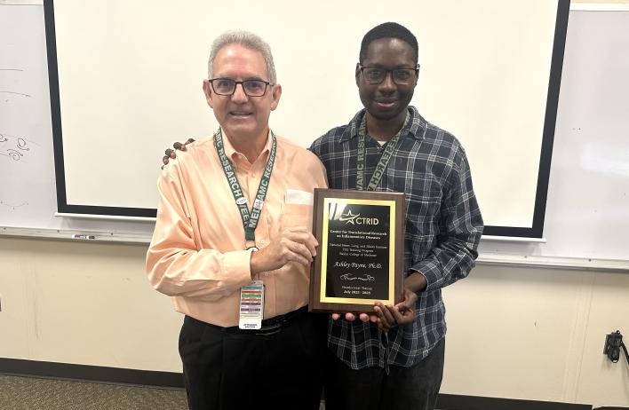 CTRID T32 Director, Dr. Rolando Rumbaut (left) presenting a graduation plaque to Dr. Ashley Payne (right).