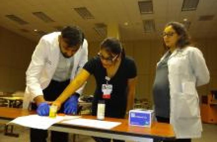 3 people standing over a table