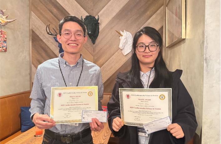 two people holding award certificates