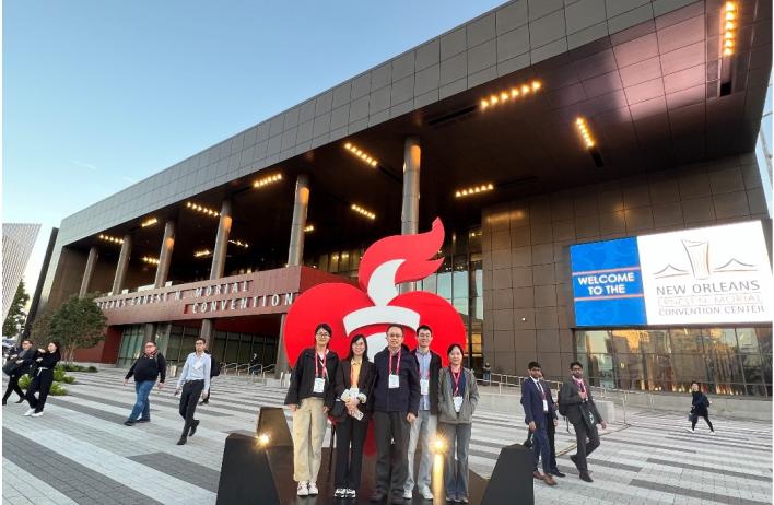 lab members standing in front of a convention center, smiling