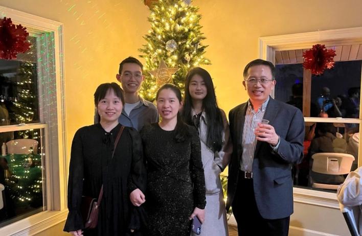 lab members standing in front of a christmas tree, smiling