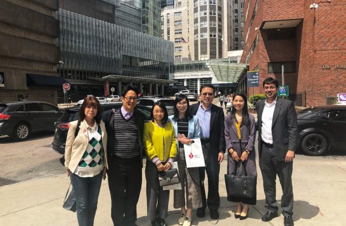 lab members smiling in fornt of Harvard Medical School