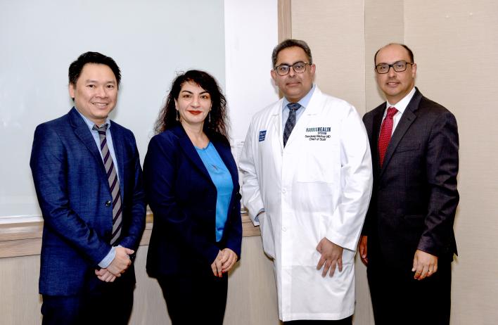 Four people smiling and posing after the conference
