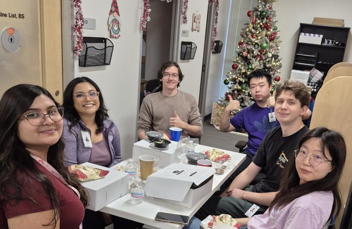 a small group of people smiling at a dinner table