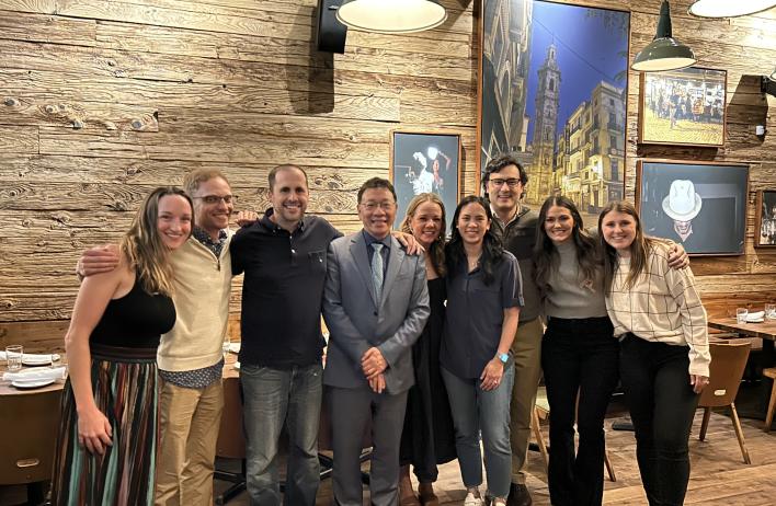 Several people posing together at a social event in a room full of cowboy-themed art.