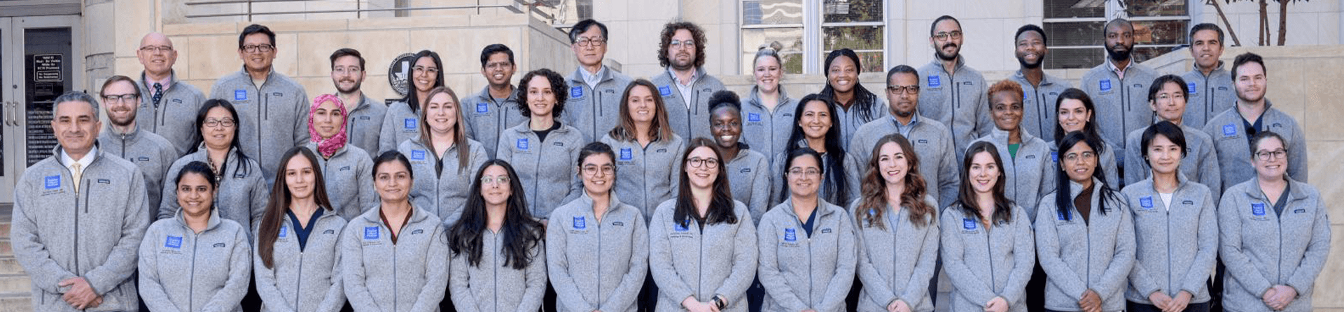 group of people in grey sweaters smiling