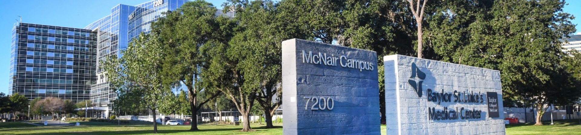 view of mcnair campus with signs and greenery