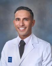 man in white coat smiling
