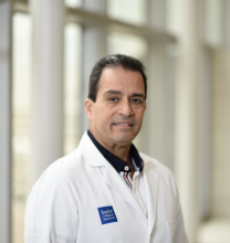 man in white coat smiling