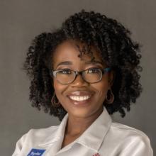 woman with short hair and glasses smiling