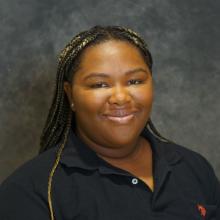 Woman smiling in front of grey background