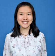 Woman smiling in front of grey background