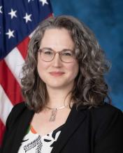 woman smiling in front of american flag