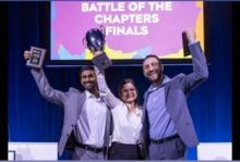 3 people holding plaques they've won 