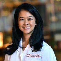 Woman smiling in front of grey background