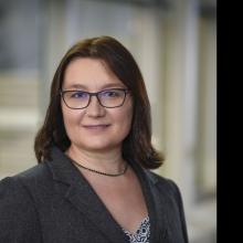 Woman smiling in front of grey background