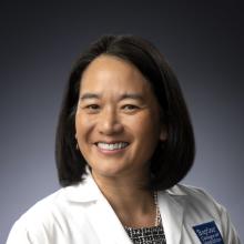 Woman smiling in front of grey background