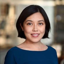 Woman smiling in front of grey background