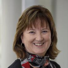 Woman smiling in front of grey background