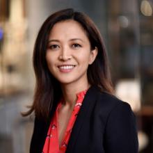 Woman smiling in front of grey background