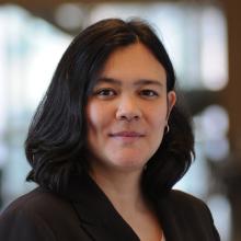 Woman smiling in front of grey background