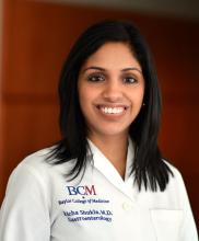woman smiling with white baylor college of medicine coat on