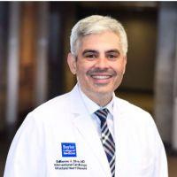 main in white doctor coat smiling