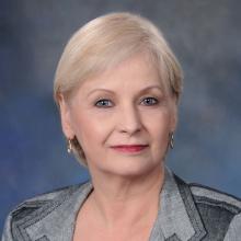 Woman smiling in front of grey background