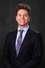 man in black suit smiling