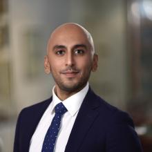 man in a blue suit and tie smiling