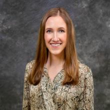 woman with long dark blonde hair smiling